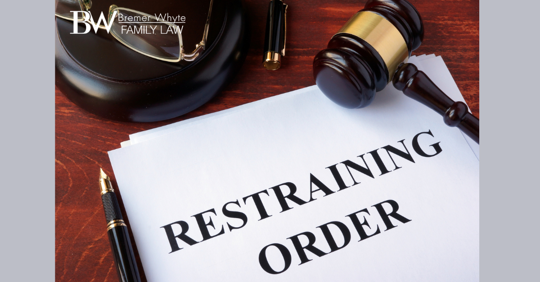 Image of gavel and document that says "Restraining Order"